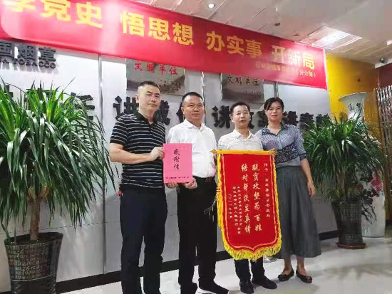 图为横江镇党委书记(左二)给石城县烟草专卖局送来锦旗和感谢信