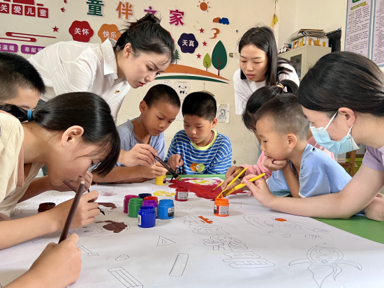 图为党员志愿者们和孩子们共绘童画 王紫玥 摄